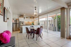 Una cocina moderna con comedor, que incluye un refrigerador de acero inoxidable, un horno y un lavaplatos.