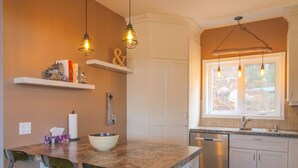 A kitchen with a central island, bar stools, a dishwasher, and pendant lighting. - Chalet Au petit Edouard (Mount Edouard) (L'Anse-Saint-Jean)