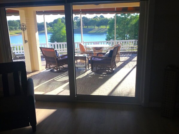 A room with a view of a lake and chairs outside. - Spectacular water and golf course views (The Villages)