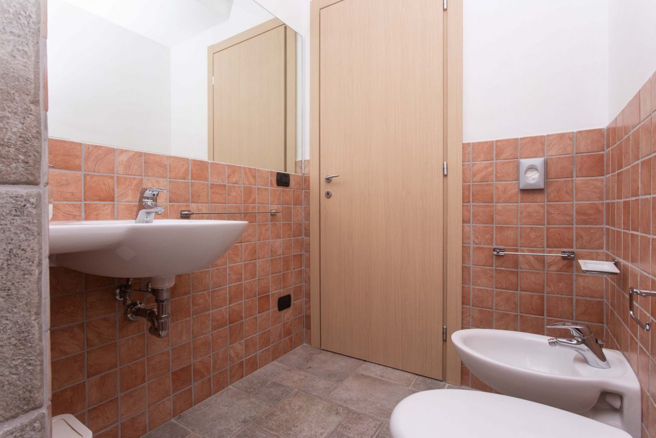 A bathroom with a sink, mirror, and toilet.