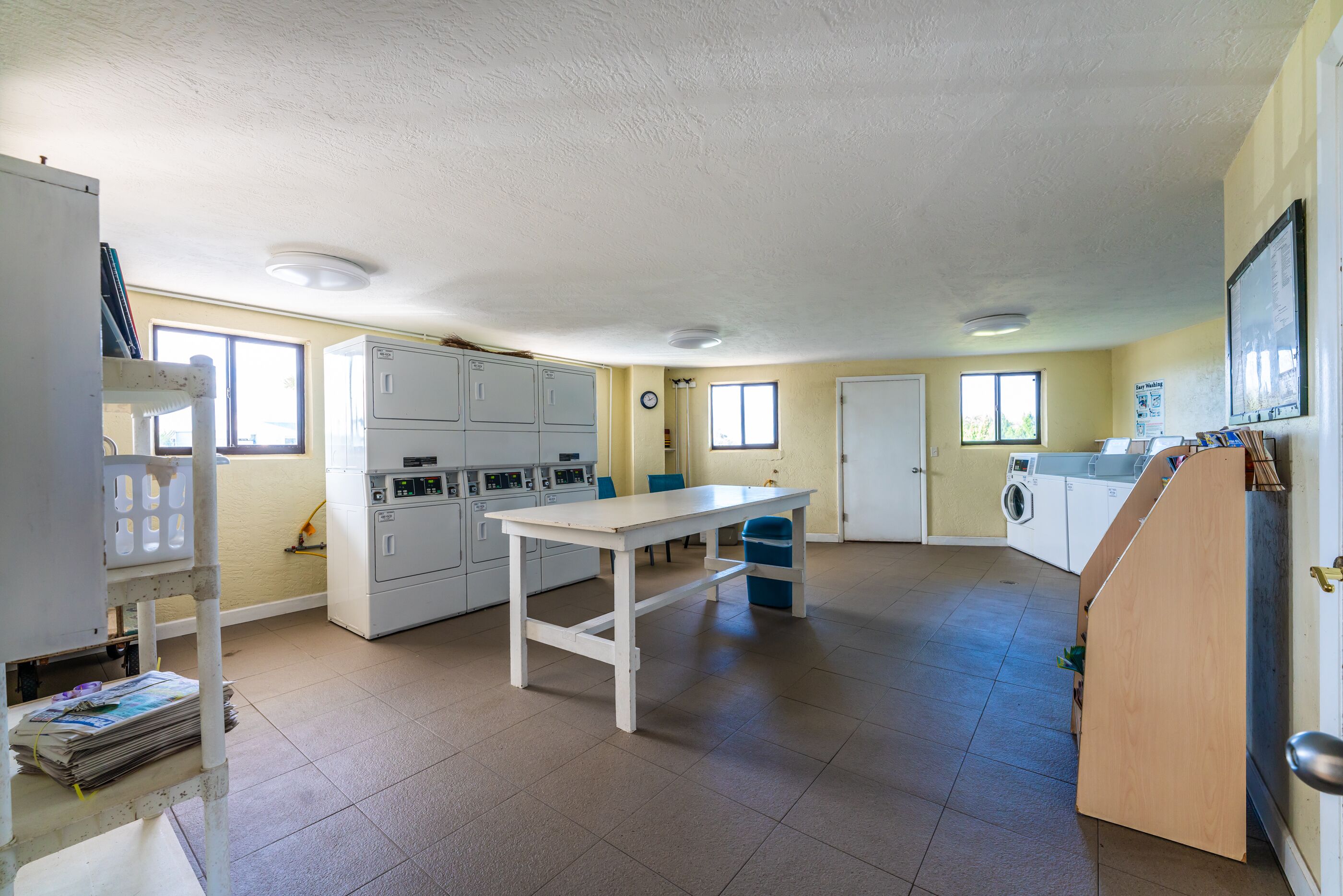 A spacious kitchen with white cabinets, a central island, and a sink.