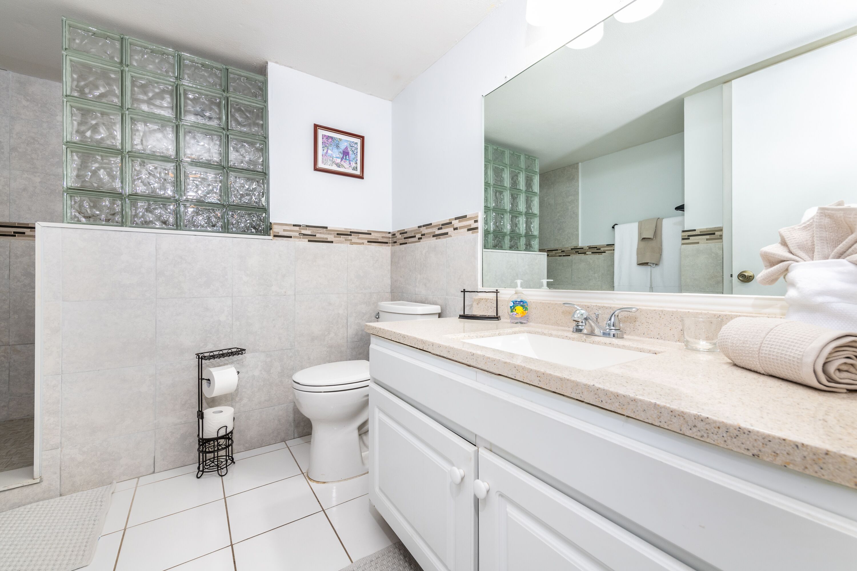 A modern bathroom with a toilet, sink, and mirror.