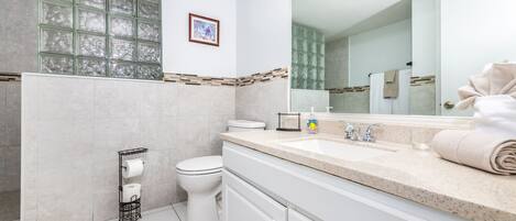 A modern bathroom with a toilet, sink, and mirror.