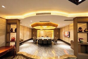 A conference room with a round table, chairs, and a decorative wall. - Lijing Peninsula Hotels (Lufeng)