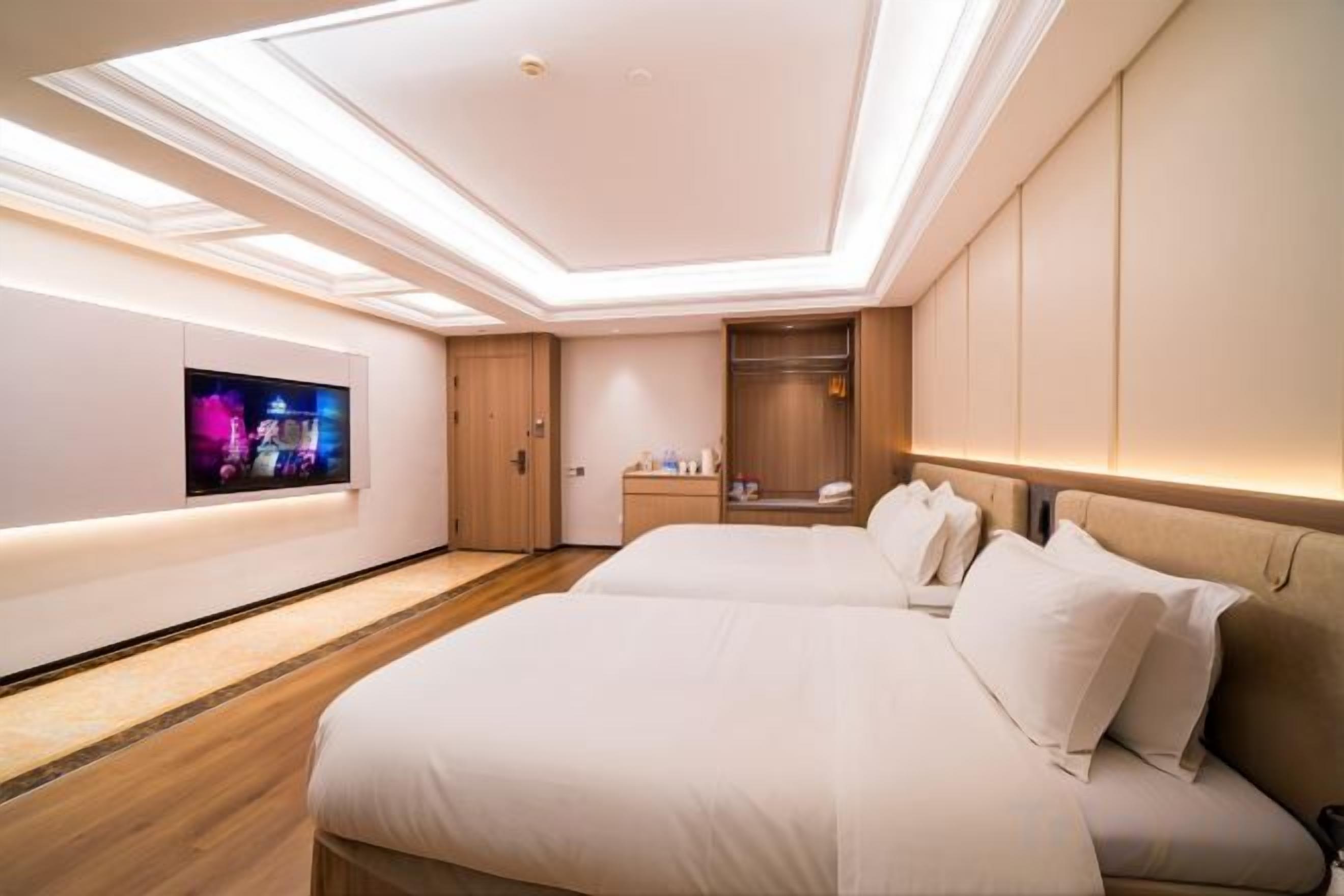 Een moderne hotelkamer met een groot bed, een televisie en een inloopkast.