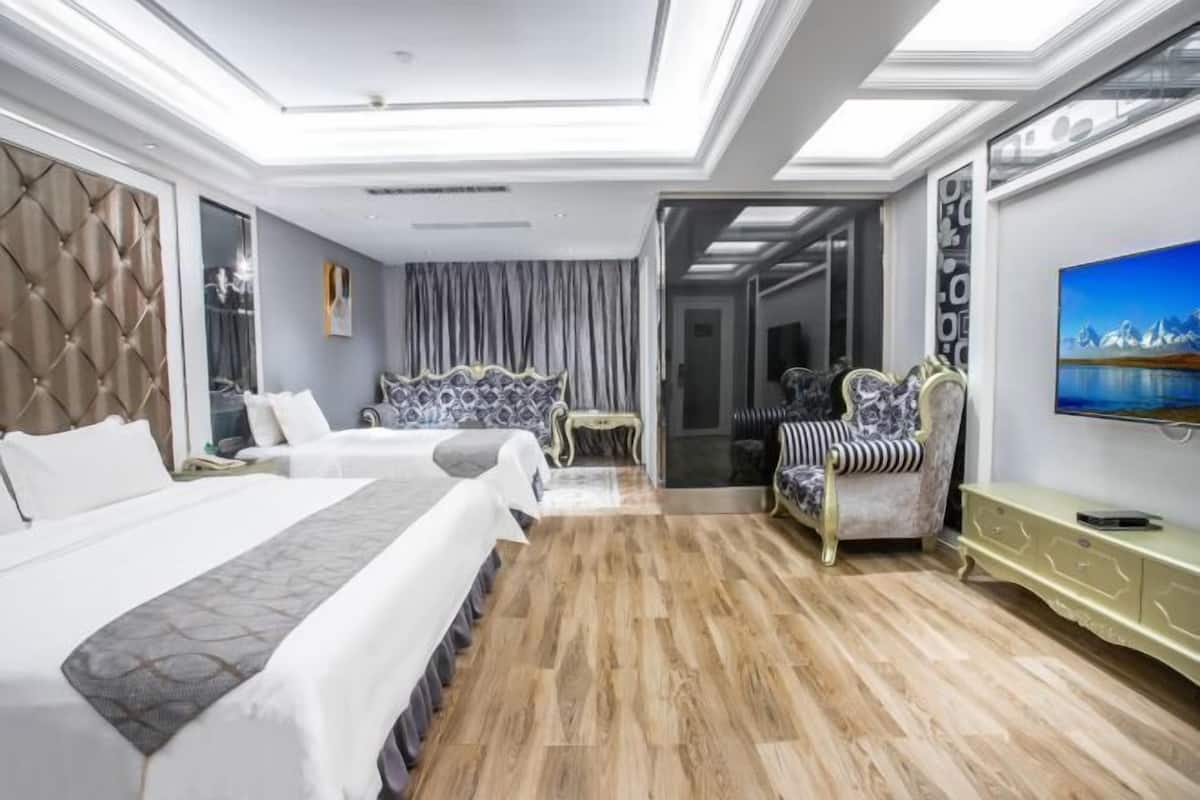 A hotel room with two beds, a large mirror, a television, and a view of the outdoors.