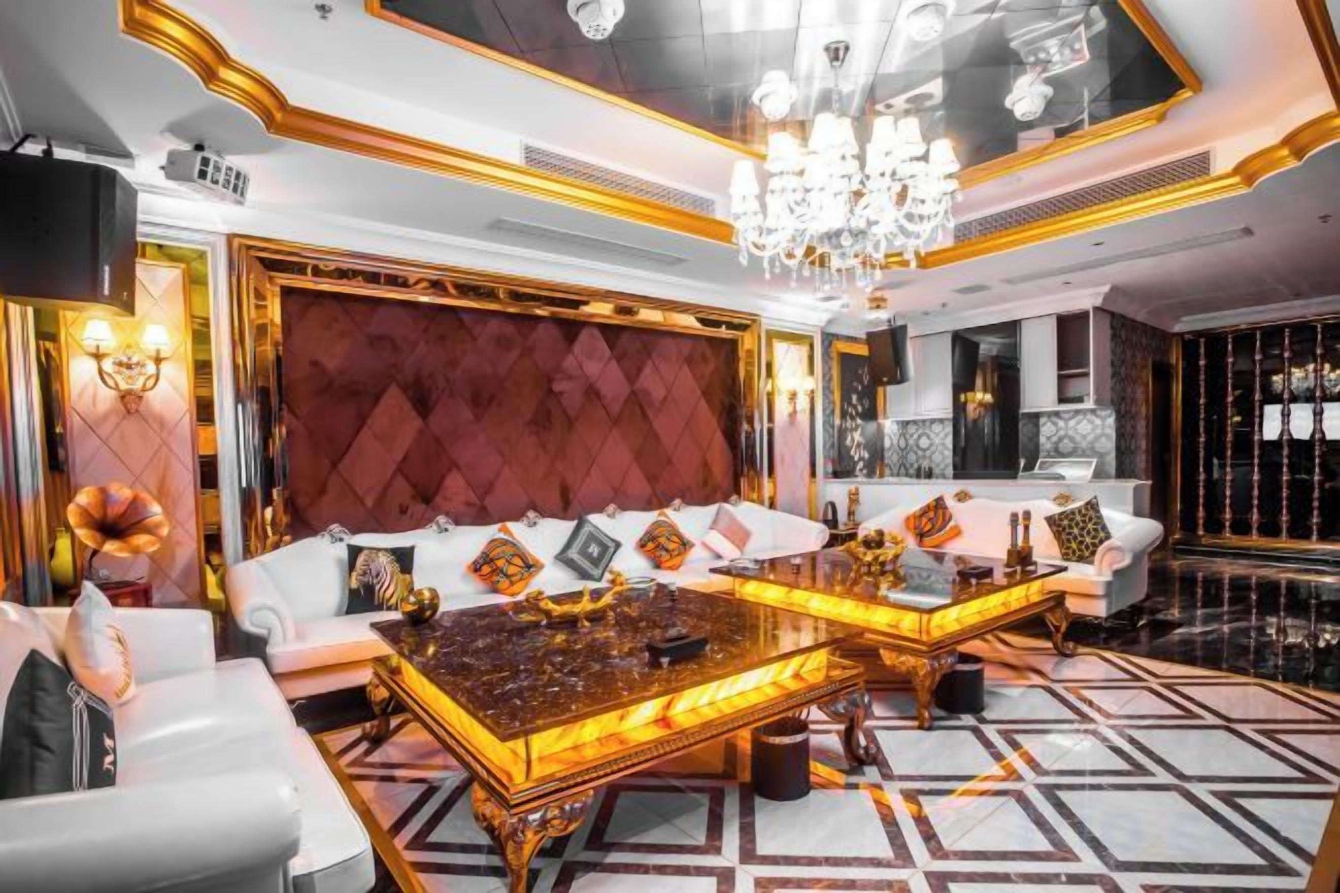 Ein luxuriöses Wohnzimmer mit einer großen Couch, einem Couchtisch und einem Kronleuchter.