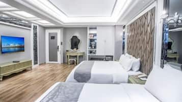Una habitación de hotel moderna con una cama grande, un escritorio, un televisor y un armario.