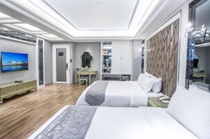 Una habitación de hotel moderna con una cama grande, un escritorio, un televisor y un armario.