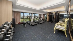 A gym with treadmills, elliptical machines, and weightlifting equipment. - Lijing Peninsula Hotels (Lufeng)