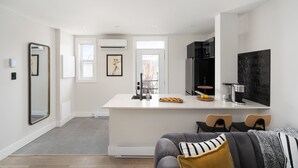 Une cuisine moderne dotée d’un îlot central, de meubles de couleur noire et d’un grand pare-feu noir.