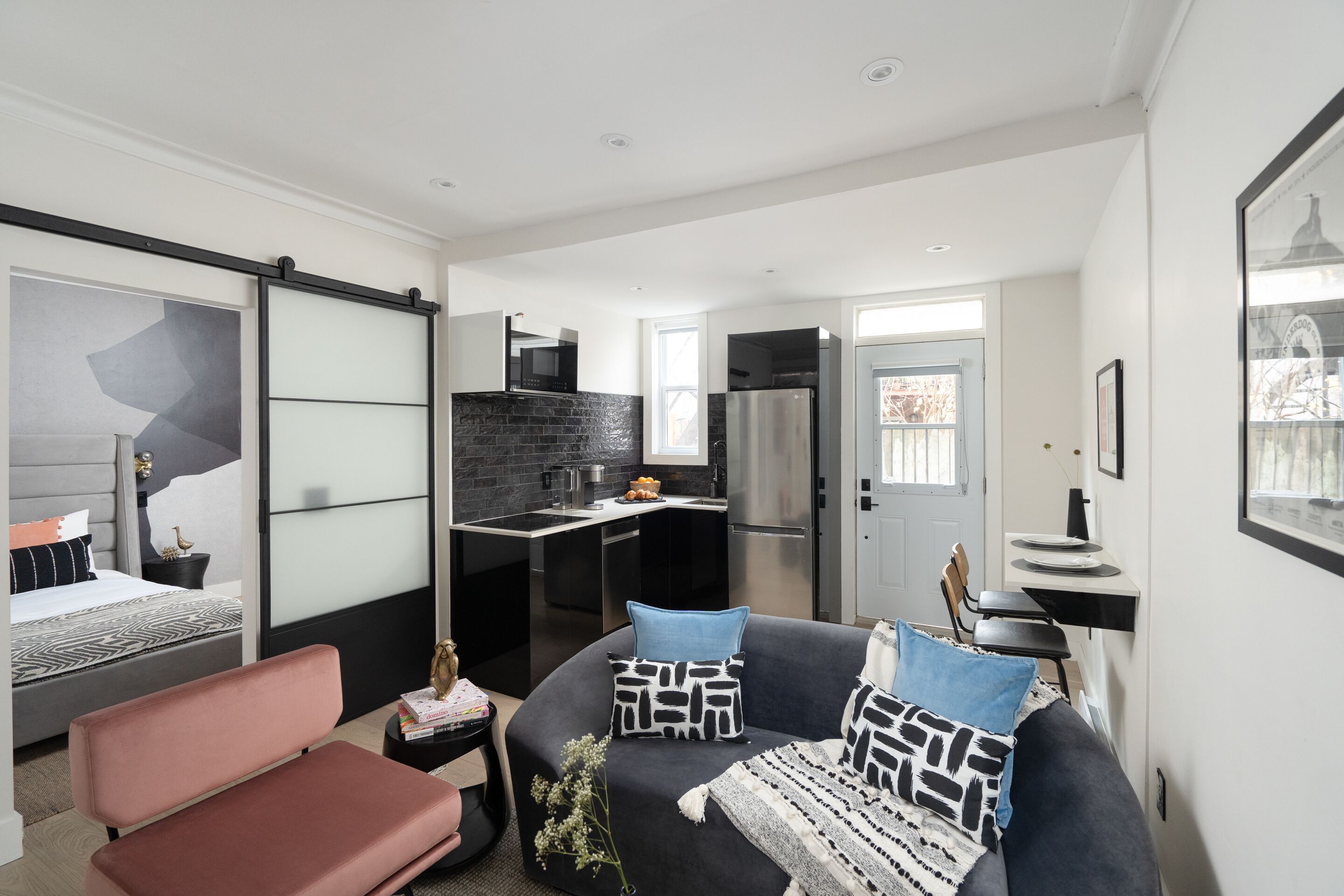 A modern apartment with a living area, kitchenette, and a bedroom.