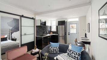 A modern apartment with a living area, kitchenette, and a bedroom.