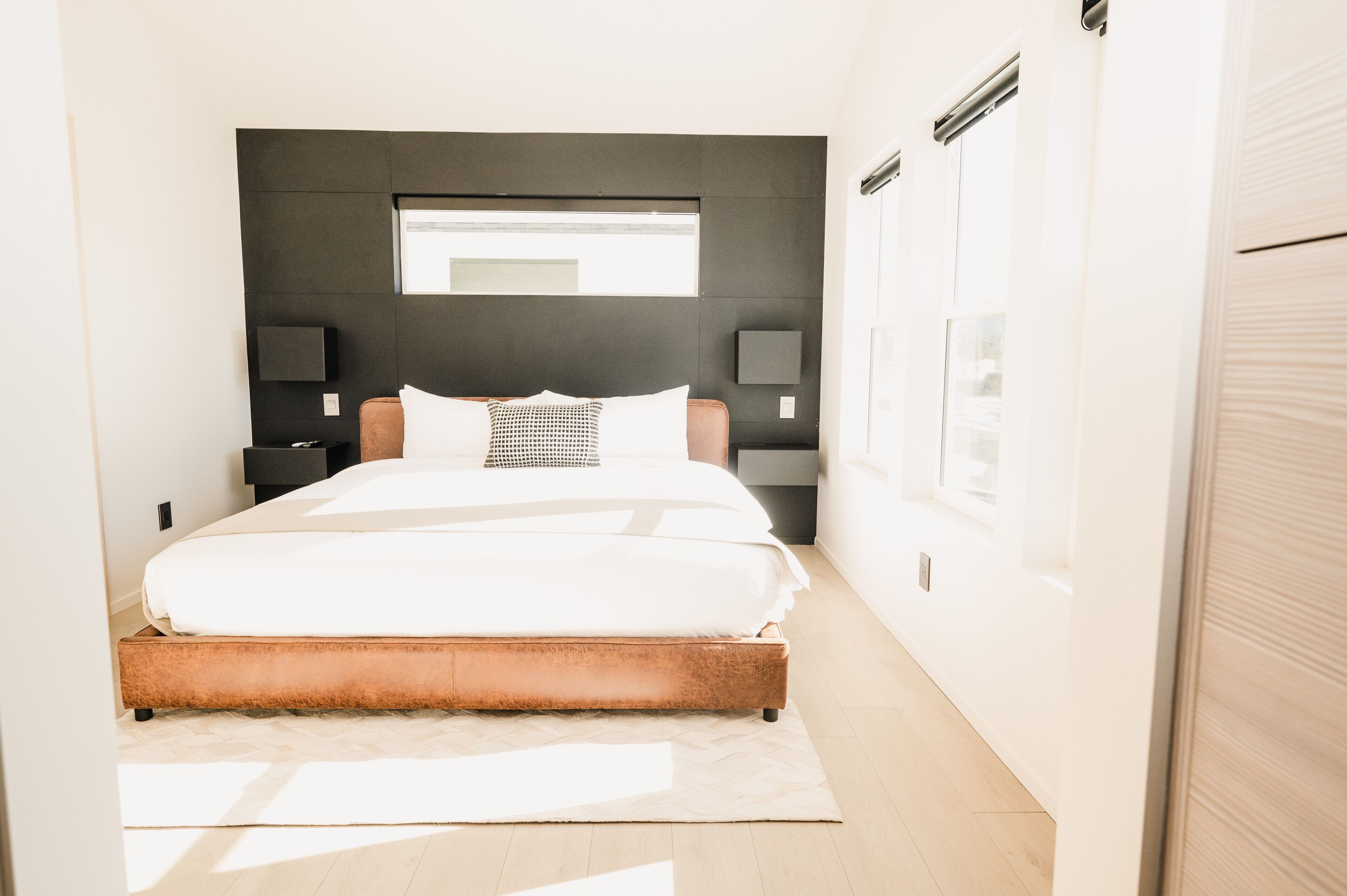 Une chambre moderne avec un grand lit, une fenêtre et un téléviseur intégré.