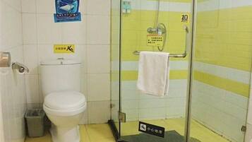 A bathroom with a toilet, a glass shower enclosure, and a towel rack.