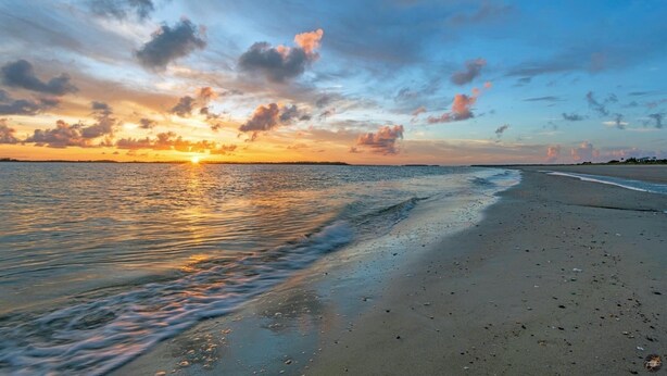 A beach at sunset with calm waves and a clear sky. - 2nd row Ocean Views 4br 3ba Sleeps 12, '26 Pool Amenity Card, linens included (Edisto Island)