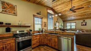A kitchen with wooden cabinets, a stainless steel stove, and a dishwasher.