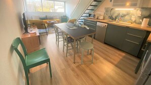A compact kitchen with a dining area, a staircase, and a view of the outdoors. - Combrit, nice duplex with heated pool, tennis court and beach on foot (COMBRIT)