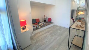 A modern apartment with a loft-style living area, a small dining table, and a kitchenette. - Combrit, nice duplex with heated pool, tennis court and beach on foot (COMBRIT)