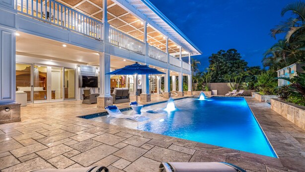 A luxurious pool area with a large pool, sun loungers, and a covered patio. - Private Luxury Villa in Kihei. Just moments walk to the beach. 10/10 reviews! (Kihei)