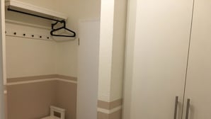 A walk-in closet with a bench, a hanging rod, and a wardrobe. - Strandhausvilla Wo. 2 - "Strandhausvilla - Whg.2" Beach chair included! (Dahme)