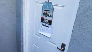 A white door with a doormat, a welcome sign, and a mailbox. - Lovely Basement with 2 Bedrooms and Kitchen (Huntington)