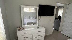 A bedroom with a bed, a dresser, a mirror, and a television. - LOVELY TWO BEDROOMS , TWO BATHROOMS IN HIGUEY (Higüey)