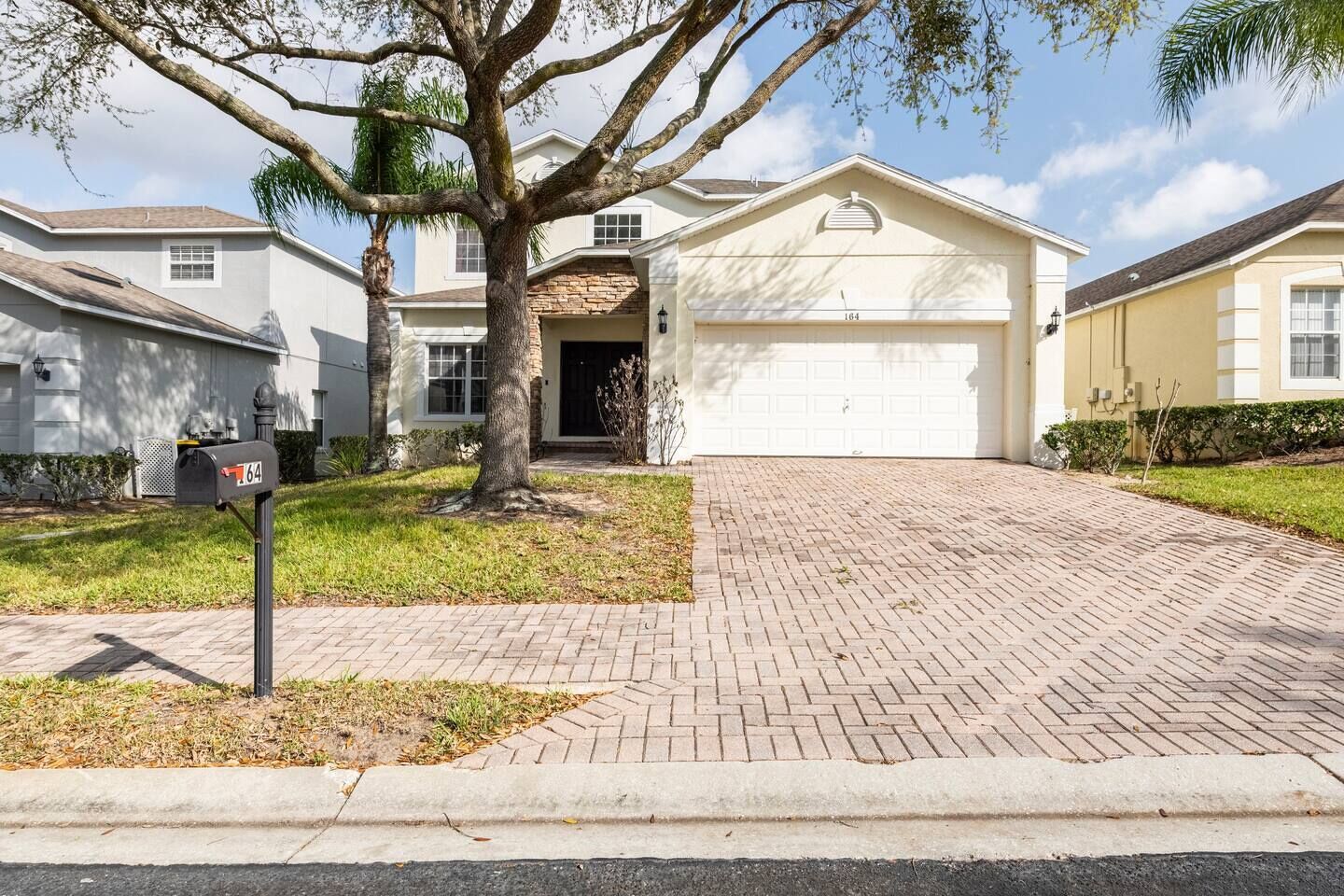 A residential house with a garage, a mailbox, and a driveway.