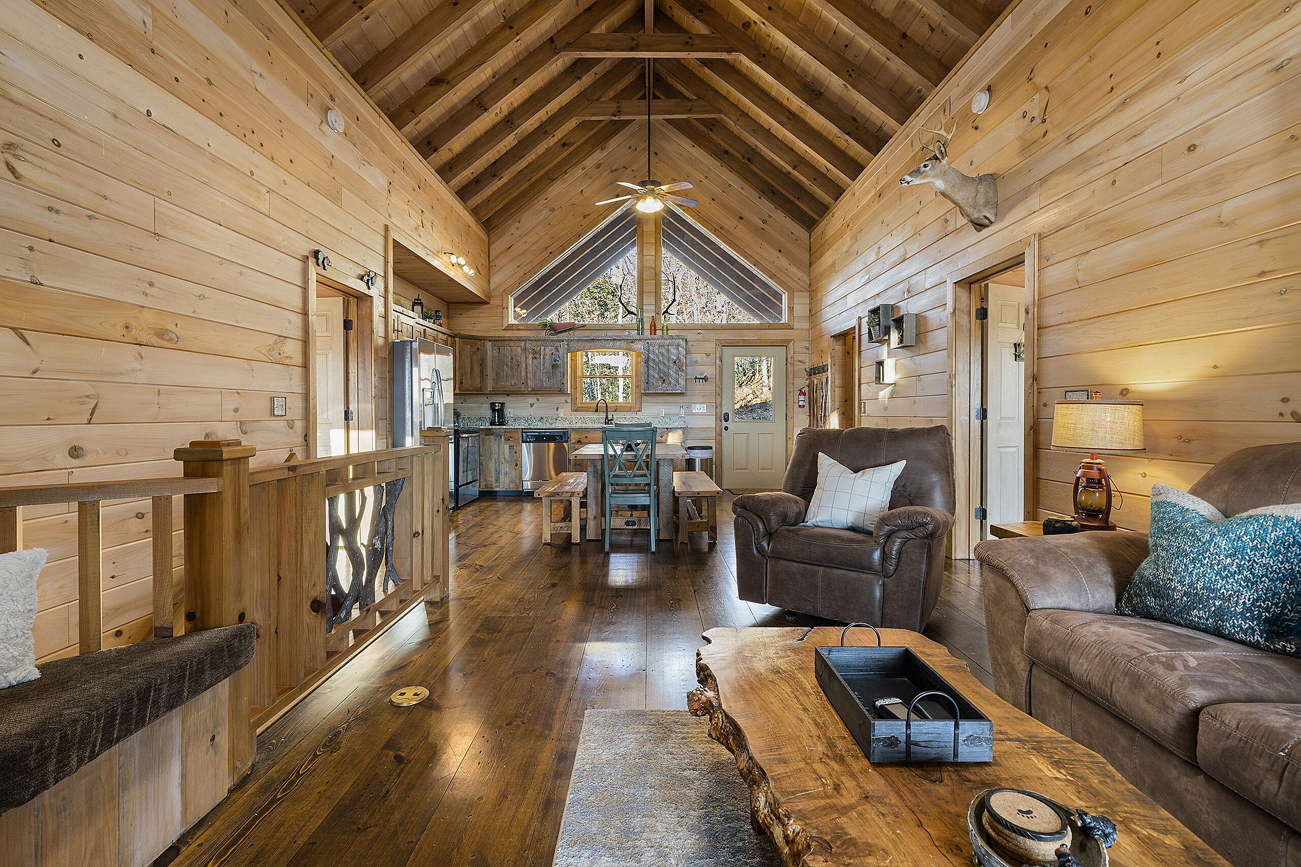 L’intérieur d’un chalet en bois comprend un coin repas, un canapé et une cheminée.