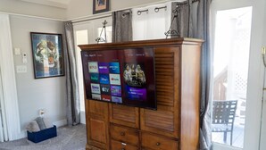 Un mueble de madera con un televisor de pantalla plana que muestra varios servicios de transmisión.