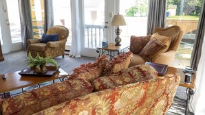 Una sala de estar con un sofá, sillones, una mesa de centro y una lámpara.