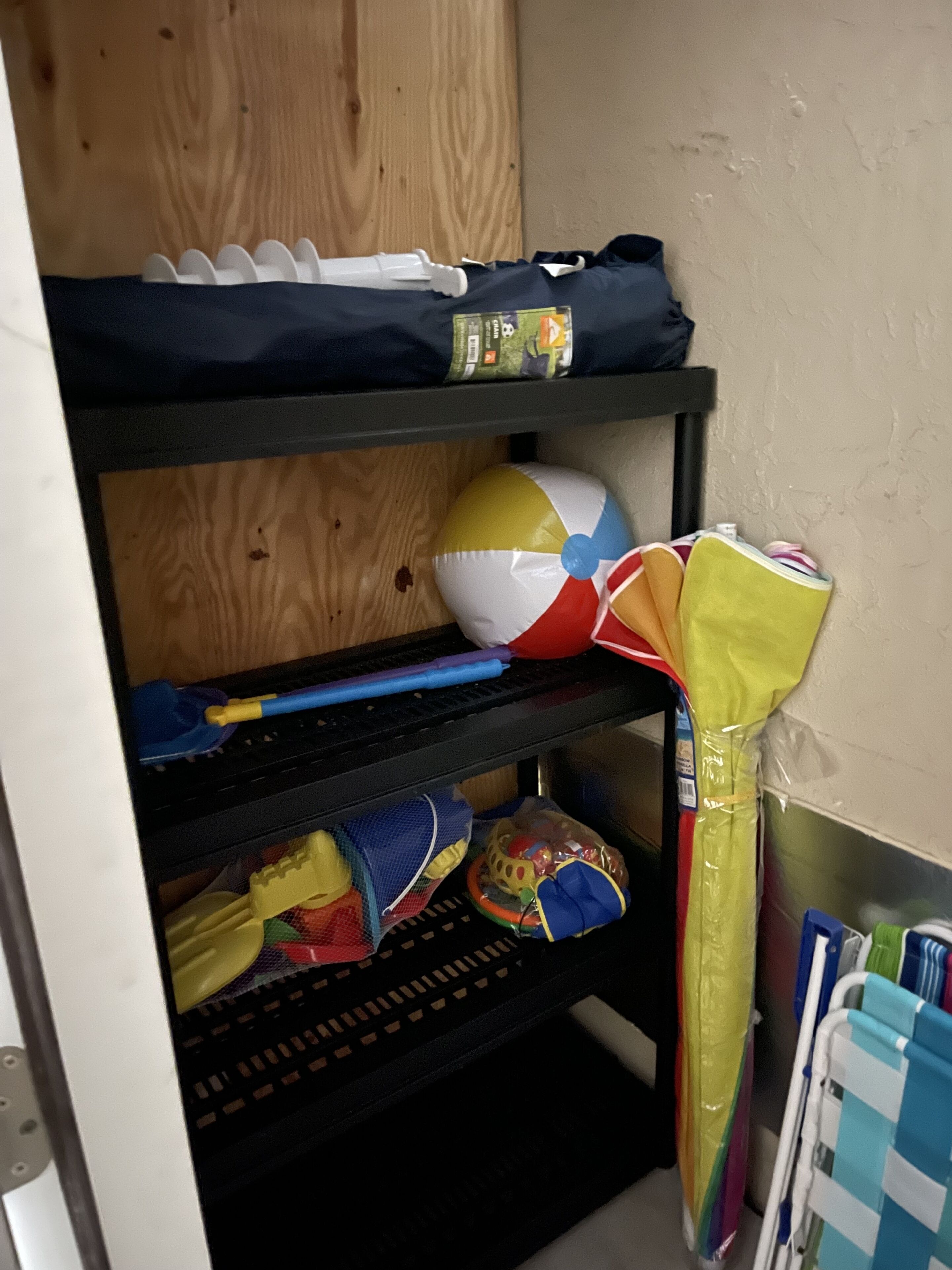 A bunk bed with a shelf above containing a bag and a toy.