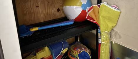 A bunk bed with a shelf above containing a bag and a toy.