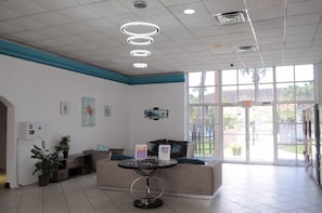 A reception area with a sofa, a round table, and a glass door leading outside.