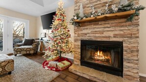 A living room with a fireplace, a Christmas tree, and a stone wall. - Pools, Hiking & Lake, Ping Pong, Shuffleboard!    Close to SDC, Lake, Shows (Branson West)