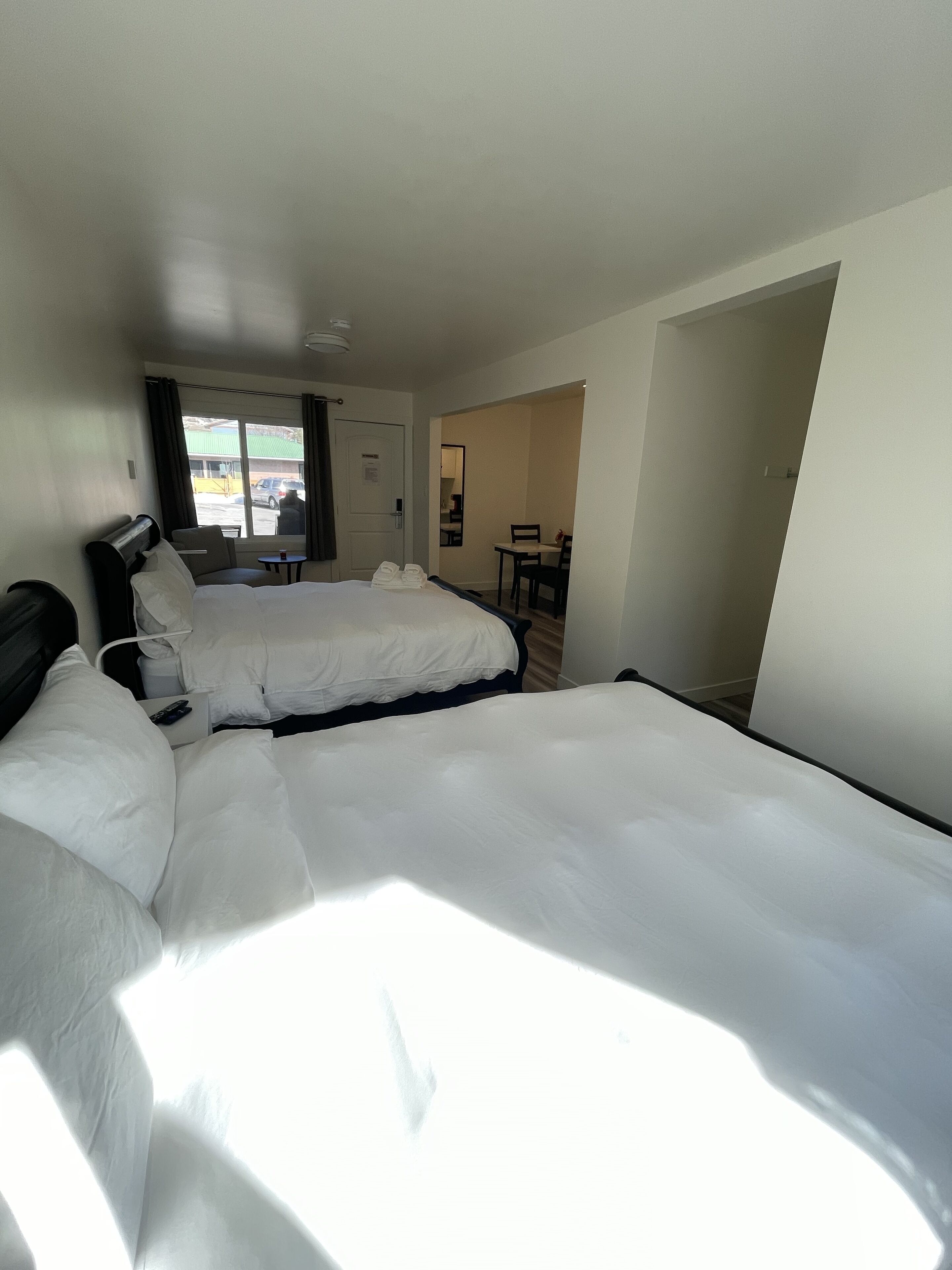 Habitación de hotel con dos camas, un escritorio y una silla.