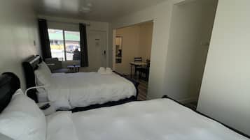 Habitación de hotel con dos camas, un escritorio y una silla.