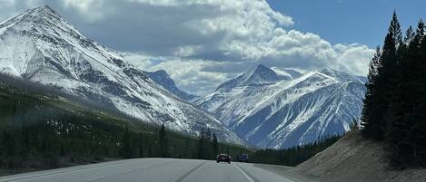 A highway with snow-covered mountains and a clear sky.