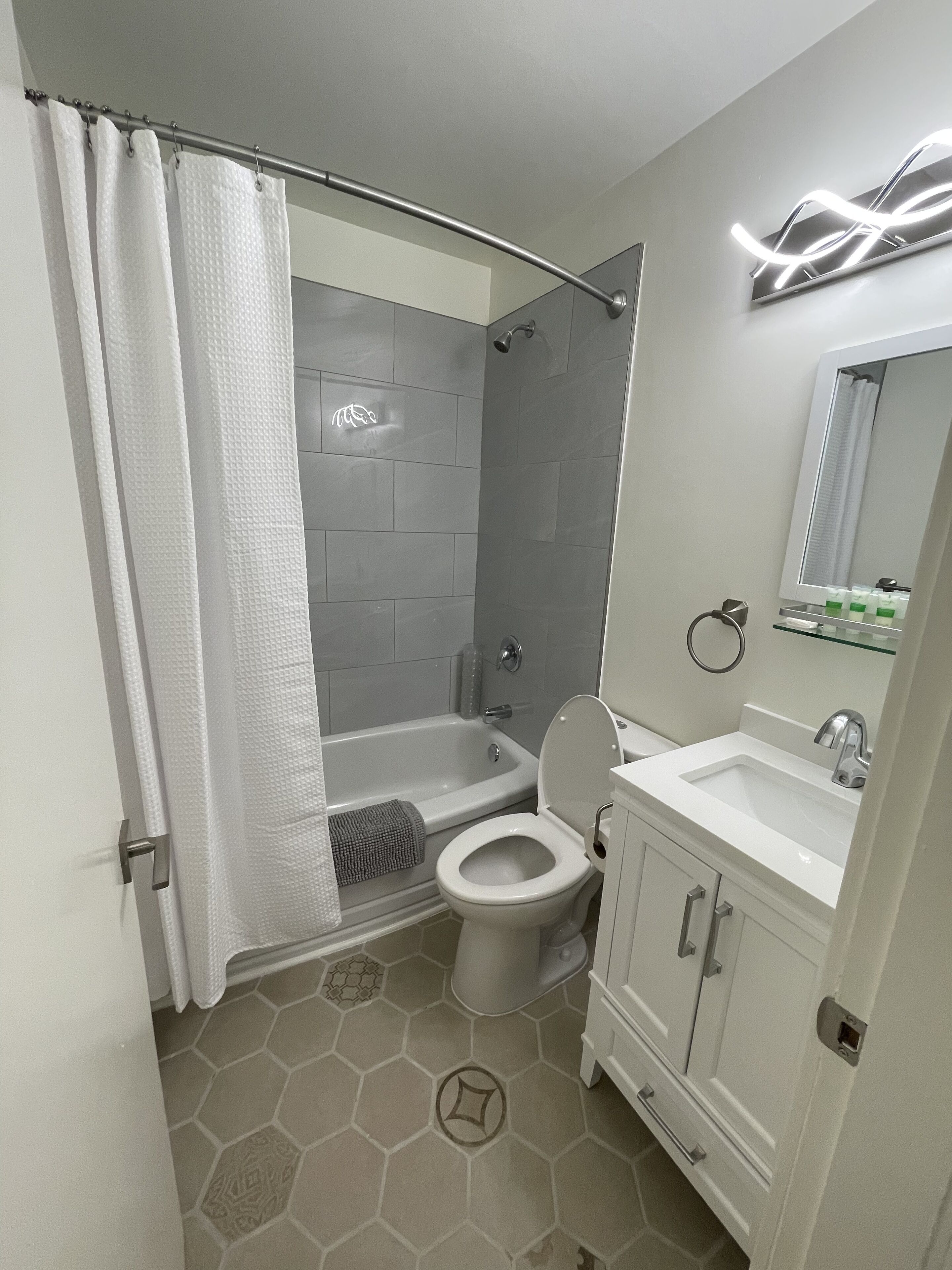 Et moderne badeværelse med bruser, toilet og vask.