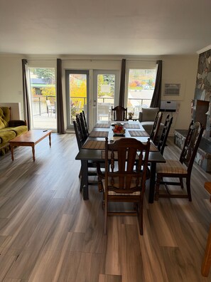 A dining area with a table and chairs, a sofa, and a fireplace. - Destination Inn (Radium Hot Springs)