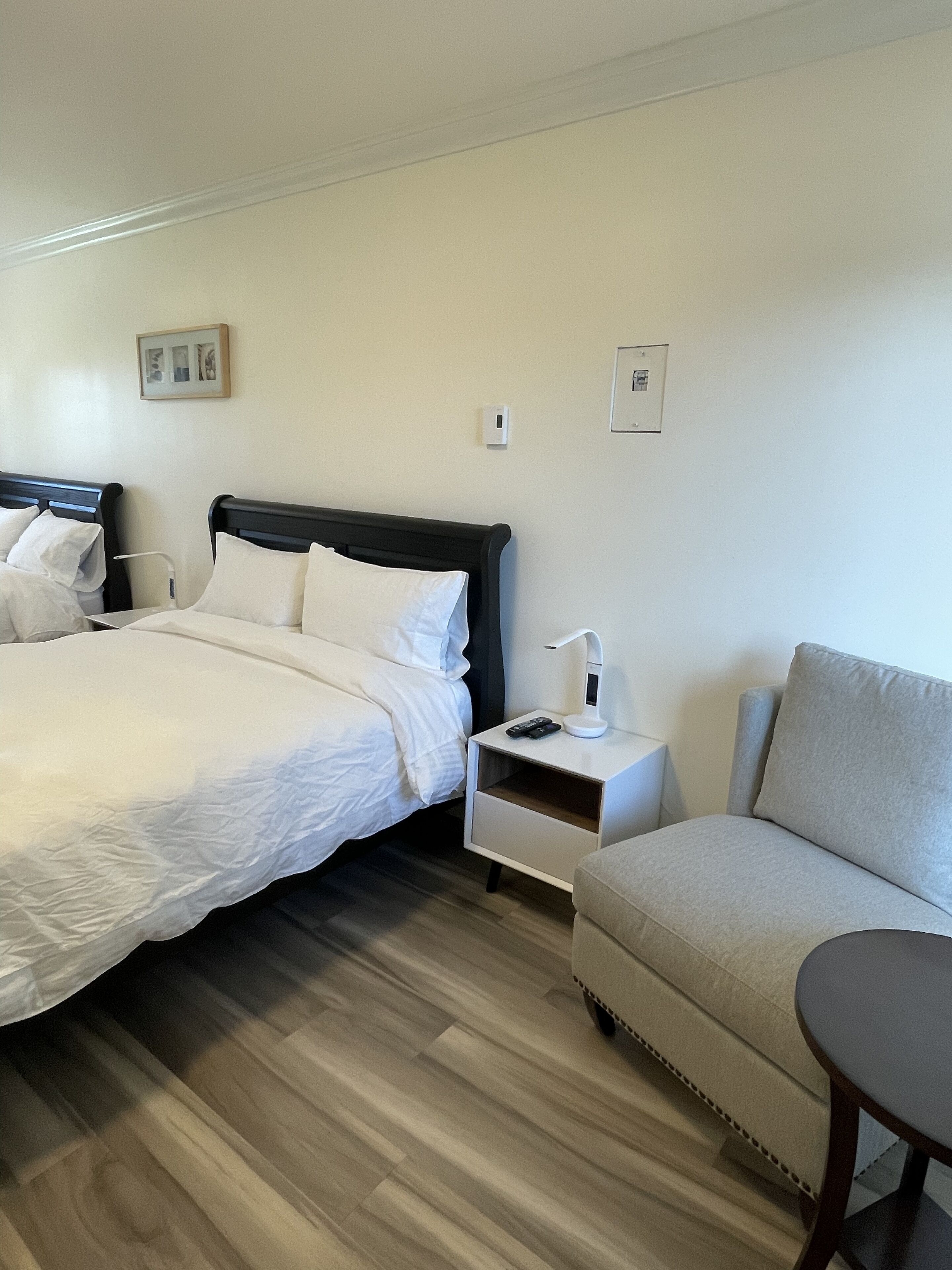 Une chambre d’hôtel avec un lit, une table de chevet, une lampe et un canapé.