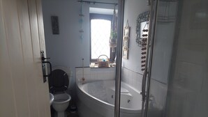 Een badkamer met toilet, bad en douche.