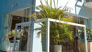 Un edificio moderno con grandes ventanales y una planta en primer plano.