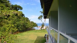 Una propiedad residencial con vistas al mar, un césped bien cuidado y una escalera que lleva a la entrada.