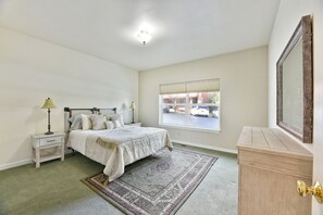 A bedroom with a bed, bedside tables, a window, and a dresser. - 230 4th Street (Ashland)