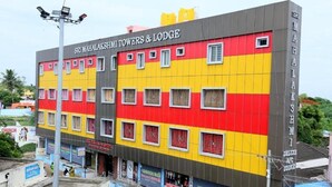 Un edificio de varios pisos con el nombre "Sri Mahalakshmi Towers & Lodge" en la fachada.
