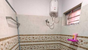 Un baño pequeño con inodoro, ducha y ventana.