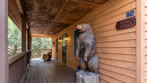 A wooden cabin with a porch, a bear statue, and a sign reading "Nuttin' Better." - Nuttin Better - App Ski Mtn cabin with hot tub, game table (Blowing Rock)