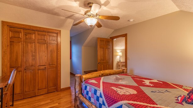 A bedroom with a wooden bed, a ceiling fan, and wooden wardrobes. - Nuttin Better - App Ski Mtn cabin with hot tub, game table (Blowing Rock)
