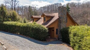 A cabin with a stone chimney, wooden siding, and a gravel driveway. - Nuttin Better - App Ski Mtn cabin with hot tub, game table (Blowing Rock)